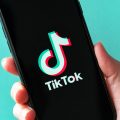 Person Holding Phone Opening TikTok App